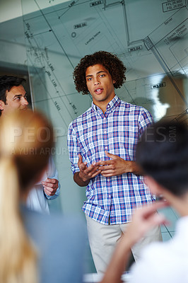 Buy stock photo Two attractive casual businessmen giving a presentation using a glass window for demonstration