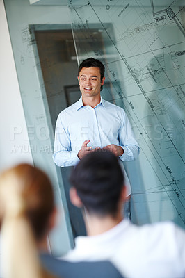 Buy stock photo Attractive casual businessman giving a presentation using a glass window for demonstration