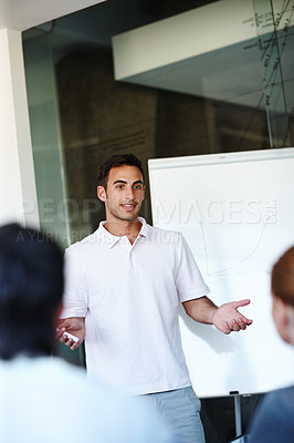 Buy stock photo Casual young businessman giving a presentation using a whiteboard