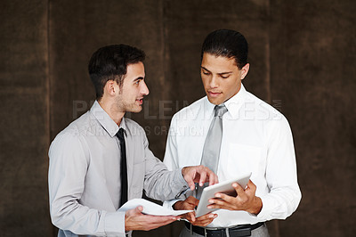 Buy stock photo Two professional businessmen having a discussion using a digital tablet