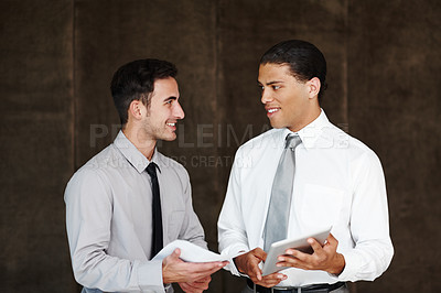 Buy stock photo Two professional businessmen having a discussion using a digital tablet