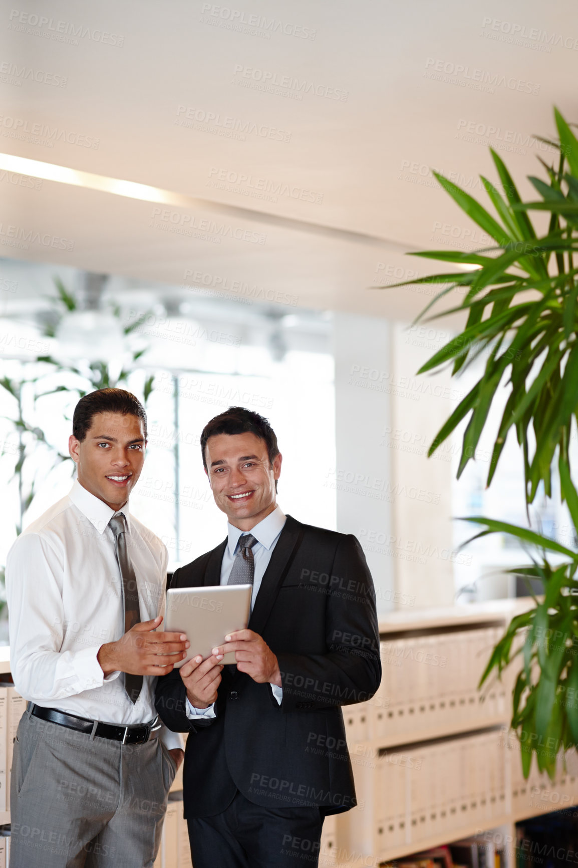 Buy stock photo Two suit-clad businessmen working together while in the office