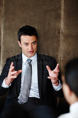 Buy stock photo Handsome young businessman conducting a consultation during a meeting