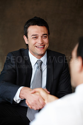 Buy stock photo Handsome young businessman shaking hands during a meeting