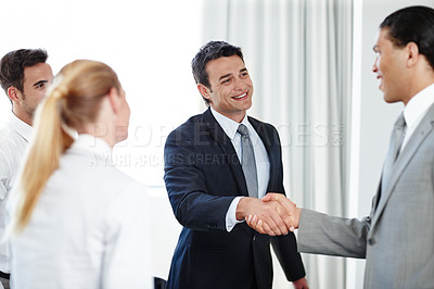 Buy stock photo A positive businessman shaking hands with a coworker during a meeting
