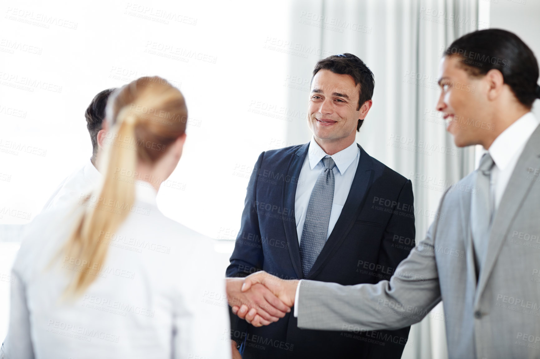 Buy stock photo A positive businessman shaking hands with a coworker during a meeting