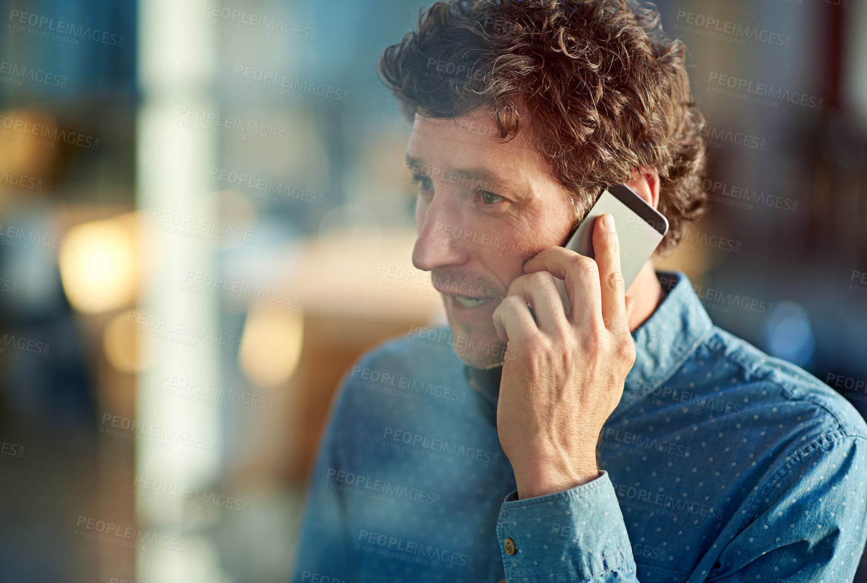 Buy stock photo Shot of a handsome businessman talking on his mobile phone in the workplace