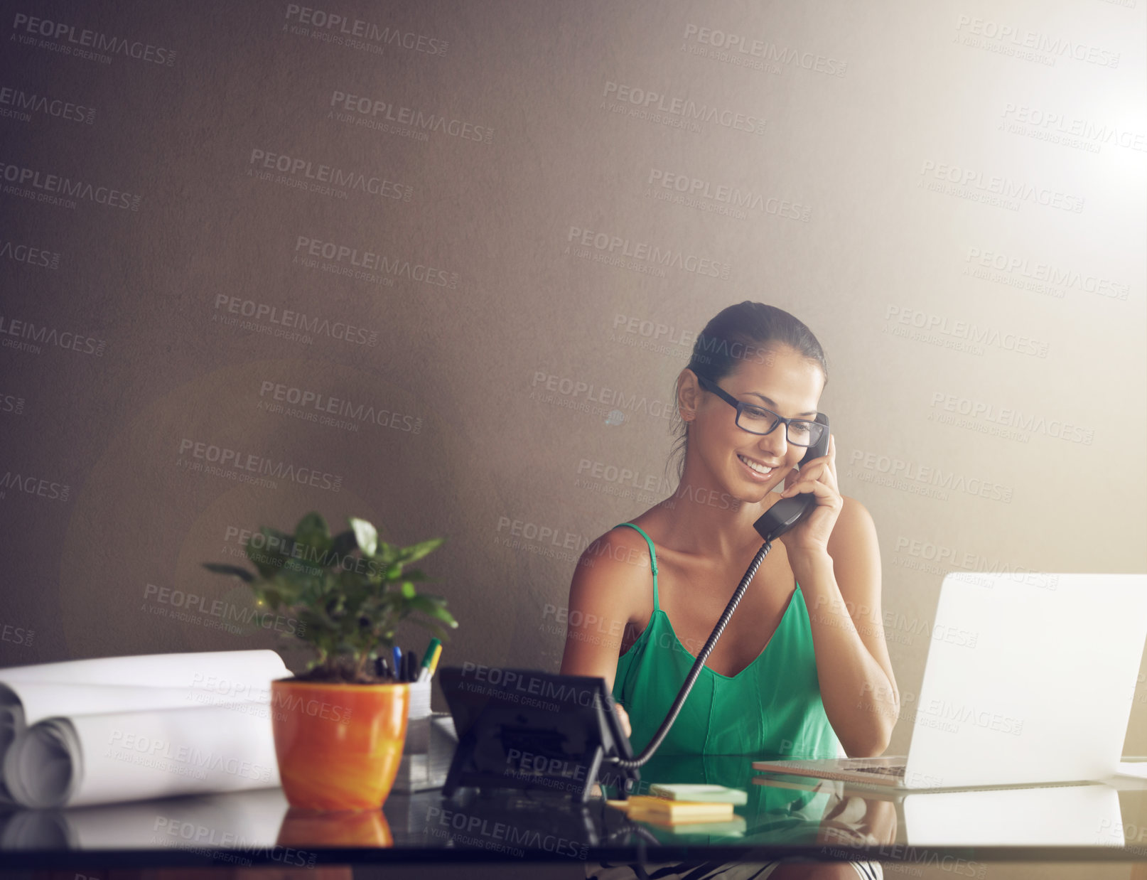 Buy stock photo Shot of a young woman talking on the phone while working from home