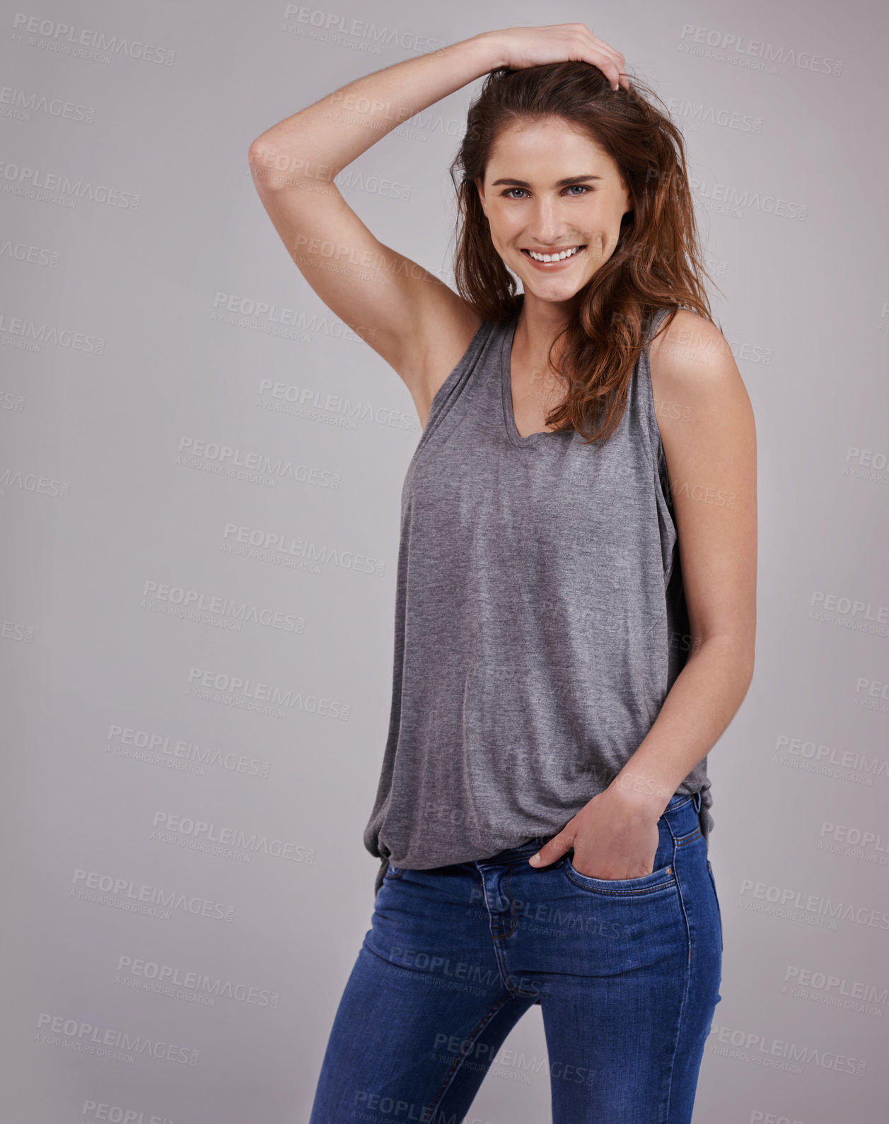 Buy stock photo Portrait, vest and happy woman in studio for fashion with trendy style, cool jeans and hand. Denim, clothes and face of female model by grey background for confidence with smile, posing and happiness