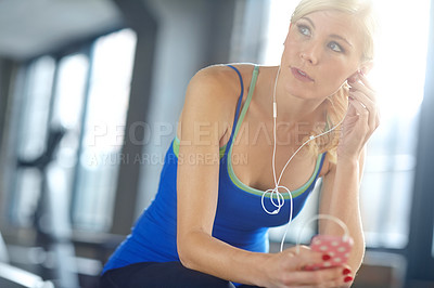 Buy stock photo Earphones, sports and woman athlete in gym listening to podcast, music or radio for motivation. Technology, exercise and female person streaming song, album or playlist for workout in fitness center.