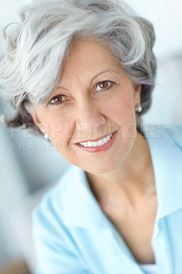 Buy stock photo Portrait of a senior woman smiling with great teeth. Happy attractive old female alone at her home. Beautiful elderly lady isolated with a grey background. Mature person looking at the camera