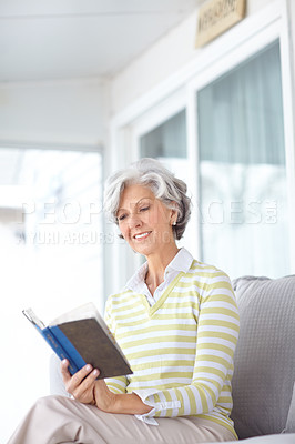 Buy stock photo Senior woman, book and reading on sofa in home with smile, literature or relax with poetry in retirement. Mature person, thinking and happy with mystery, fantasy or romance on lounge couch in house
