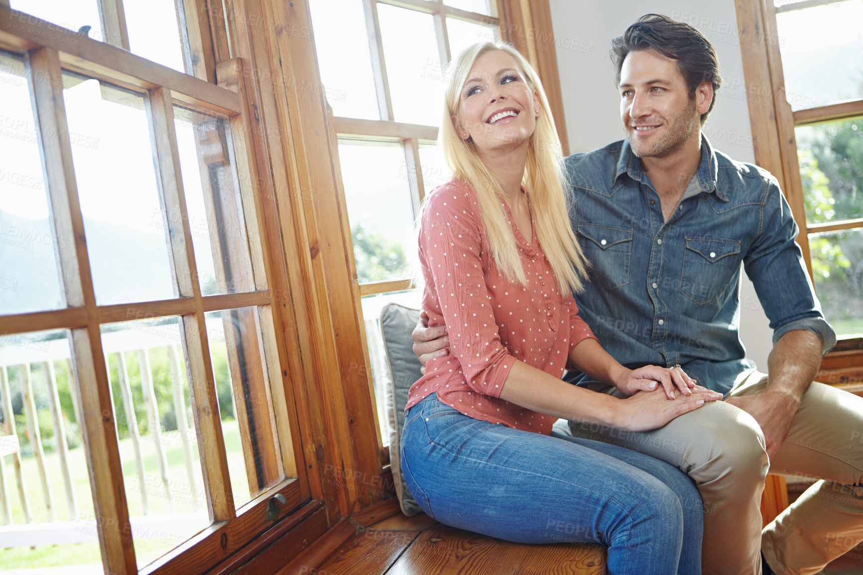 Buy stock photo Couple, together and happy on window bench for outdoor bonding, smile or people hug in apartment for support. Home, commitment for marriage and relax, romantic or relationship for security with love