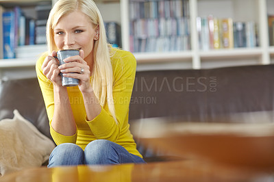Buy stock photo Portrait of a woman enjoying a cup of coffee while sitting on a sofa. One content female drinking tea in bright cozy living room. Happy young girl relaxing on the couch in lounge at home on a weekend