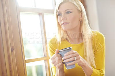 Buy stock photo Beautiful young woman daydreaming and drinking a cup of coffee while relaxing at home in the morning. One female thinking while having a drink of tea. Attractive woman enjoying a warm beverage alone