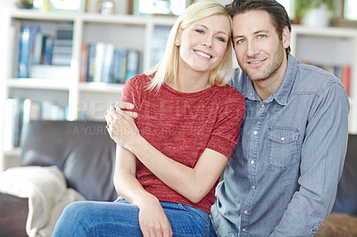 Buy stock photo Shot of a young couple sitting together in their living room