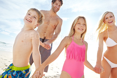 Buy stock photo Shot of a happy young family enjoying a sunny day at the beach 