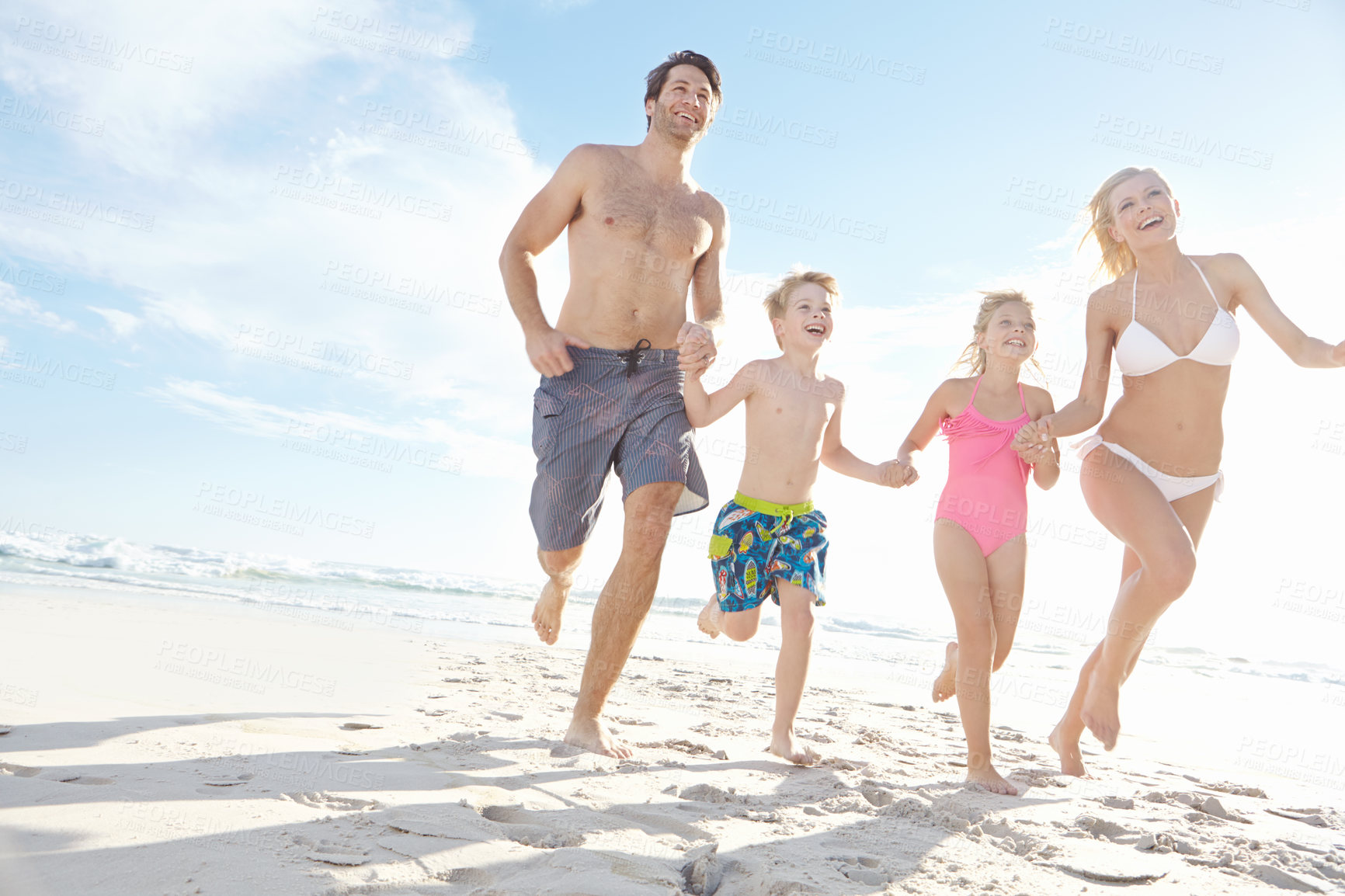 Buy stock photo Running, freedom and happy family holding hands at a beach for summer, fun and bonding in nature on vacation. Travel, energy and excited kids with parents at sea for holiday, celebration and games