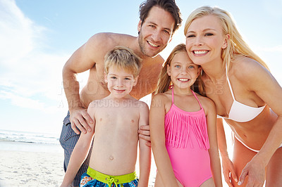 Buy stock photo Portrait of a happy young family enjoying a sunny day at the beach 