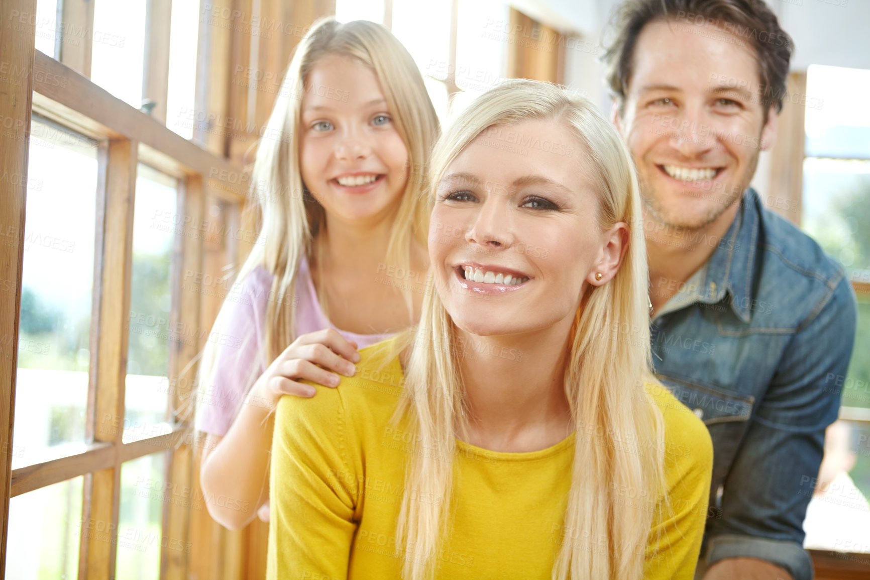 Buy stock photo Happy family, portrait and relax with window for bonding, holiday or weekend together at home. Mother, father and young daughter with smile or hug for love, care or embrace in living room at house