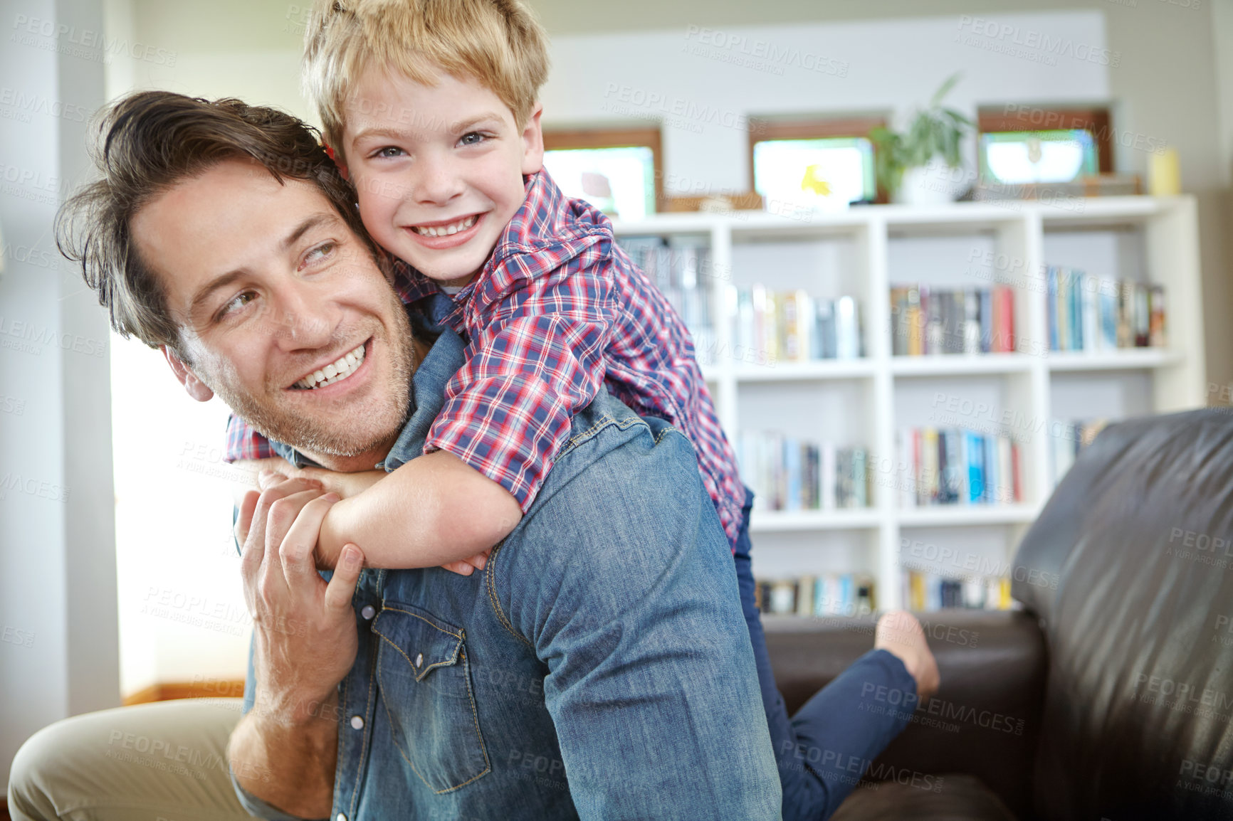 Buy stock photo Portrait, dad and child on sofa with embrace, bonding and love in living room for playful family in home. Relax, father and son on couch for happy weekend together with fun, smile and piggy back.