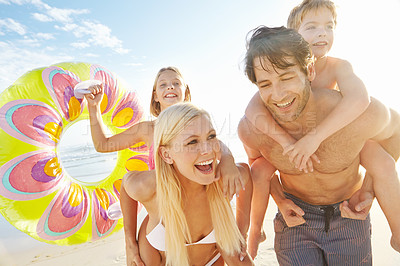 Buy stock photo Shot of a young mother and father carrying their children at the beach