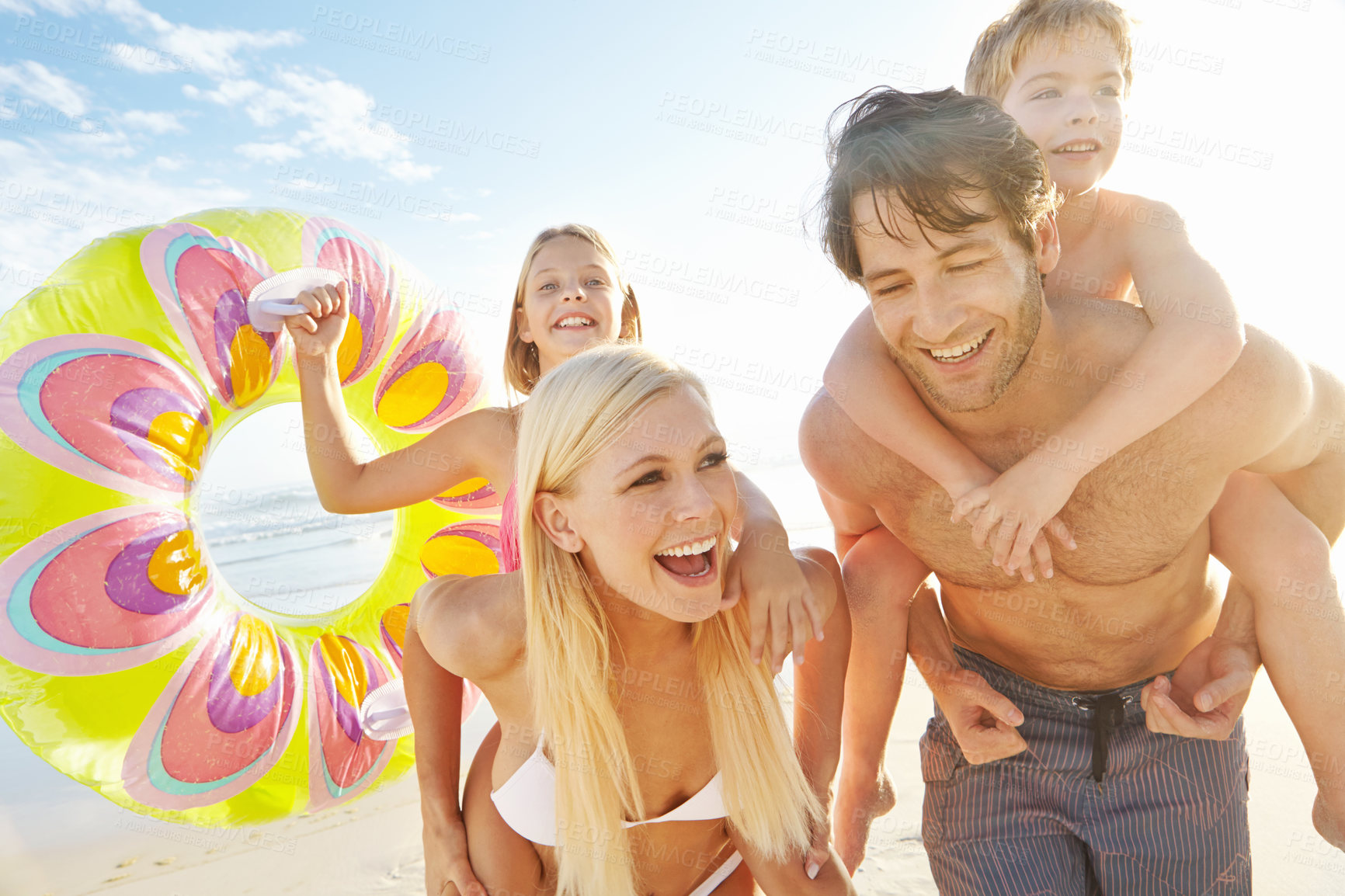 Buy stock photo Playing, piggyback and family with children at beach in swimsuit for holiday trip, summer vacation or weekend getaway. Love, happy parents and kids for travel, adventure or bonding together at sea