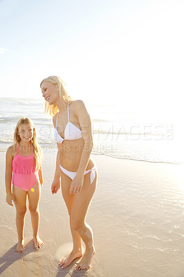 Buy stock photo Shot of a mother and her daughter standing on a beach