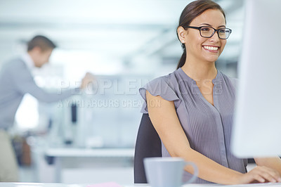 Buy stock photo Shot of an attractive young office worker sitting at her desk and working on a computer