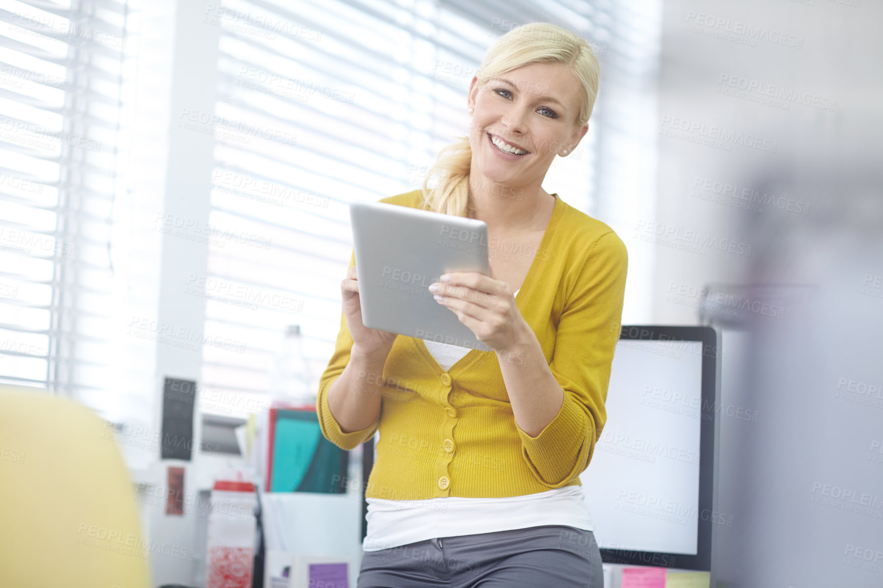 Buy stock photo Shot of an attractive young woman working on a digital tablet in an office