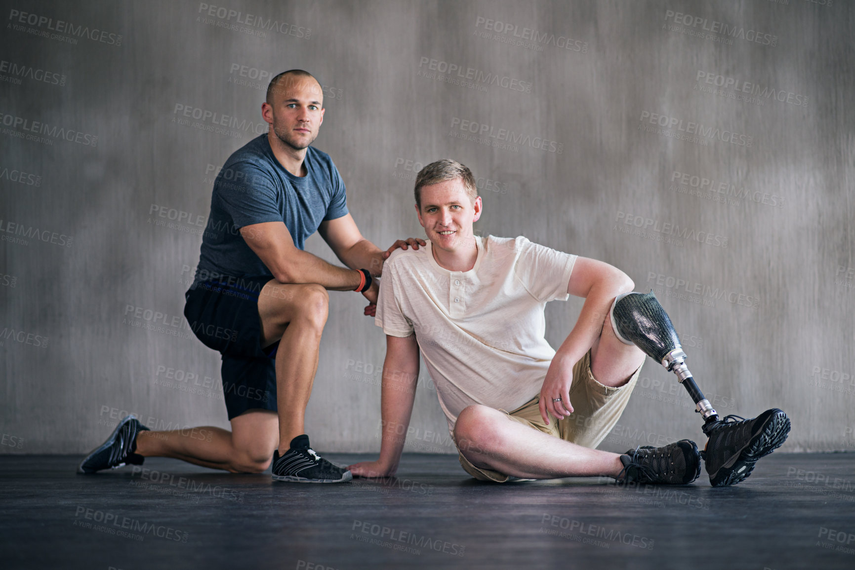 Buy stock photo Trainer, person with a disability and prosthetic leg and posing in physiotherapy, studio and gym ball. Male people, physiotherapist and amputee for wellness, fitness and exercise in sports center

