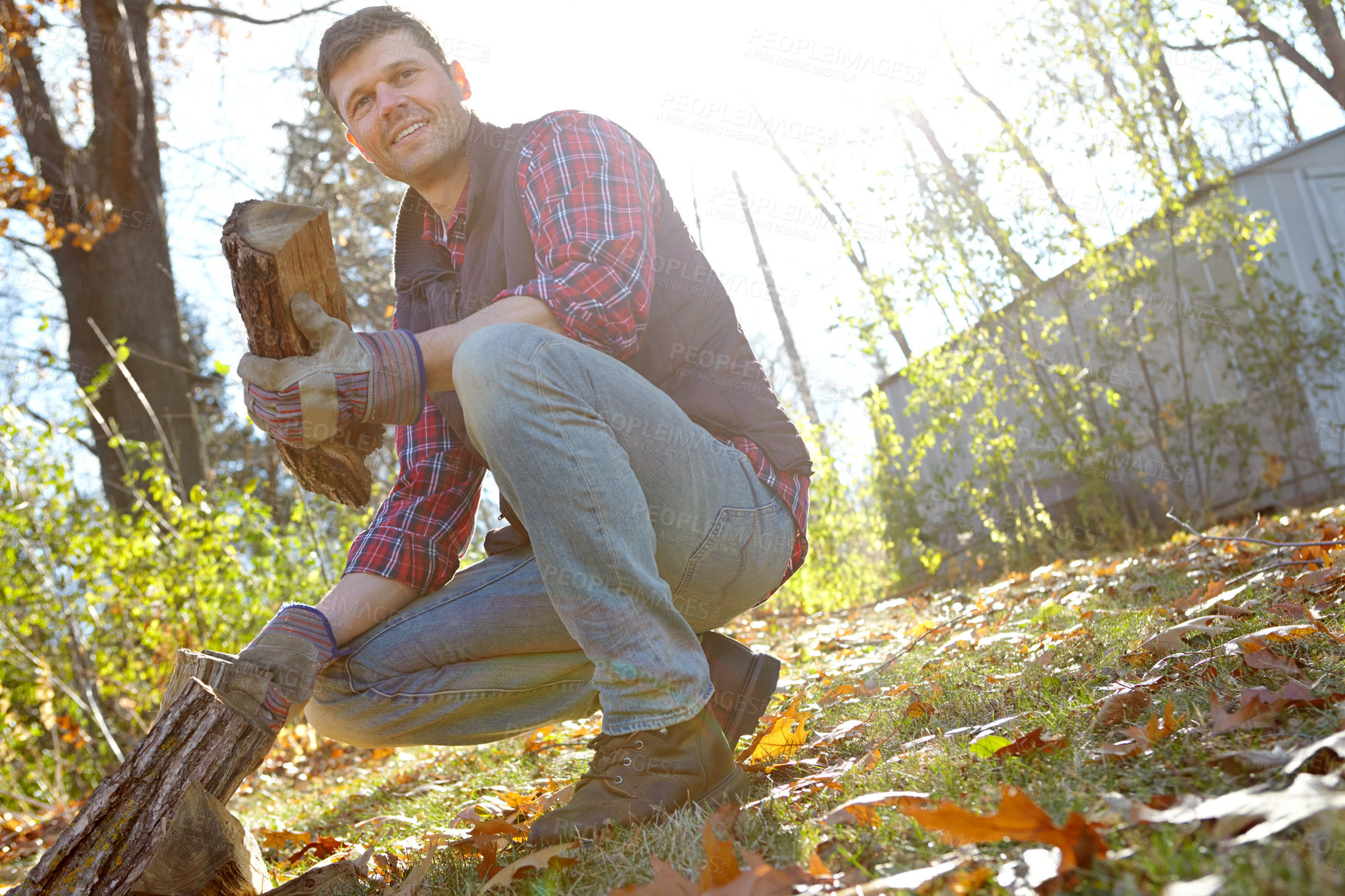 Buy stock photo Man, forest and smile with wood for fire or survival with camping, adventure and explore in Canada. Tree, outdoor and happy with firewood in nature for warmth on campsite and countryside