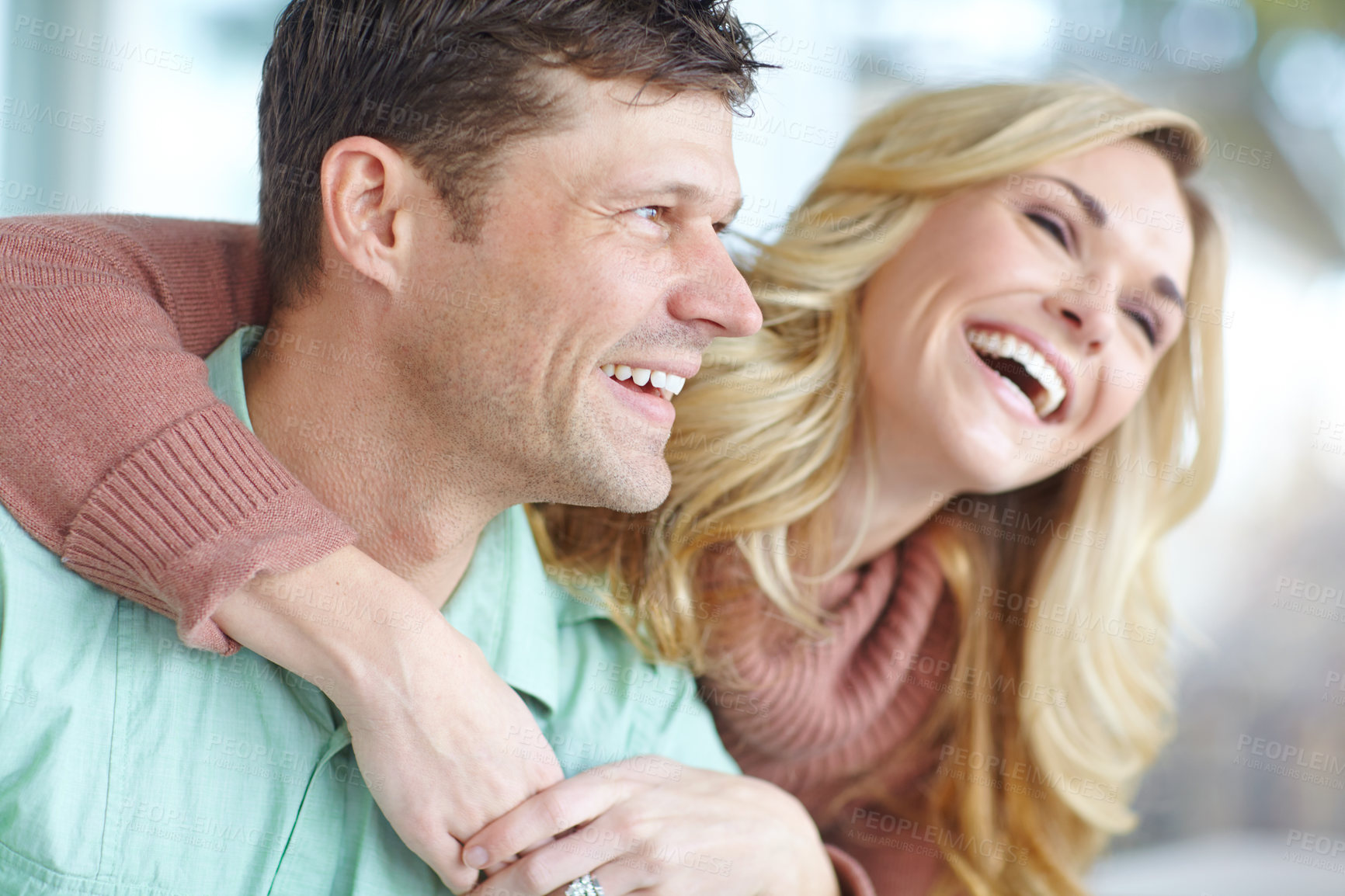 Buy stock photo Happy couple, hug and laughing in home for joke, love and comedy for bonding in relationship. People, embrace and security in marriage for commitment, funny conversation and goofy humor on weekend