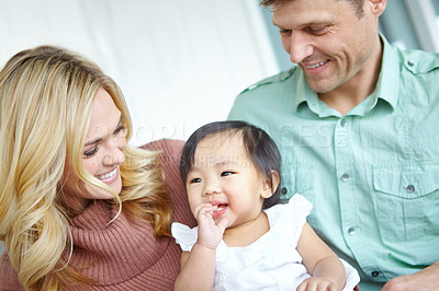 Buy stock photo Smile, family and foster baby in home for love, support or bonding together. Mother, father and cute adopted kid with parents for connection, interracial or playing with child for care in living room