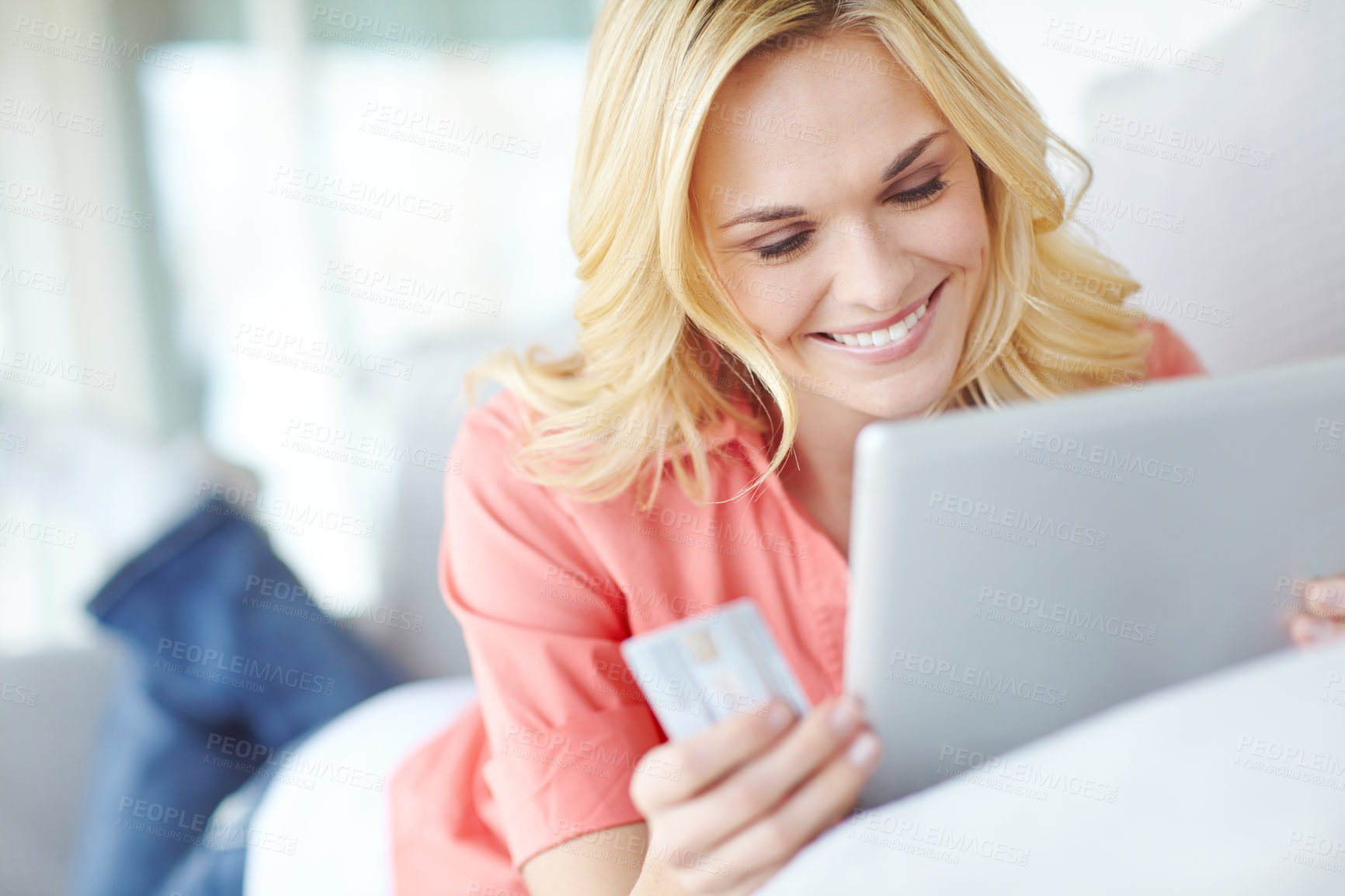 Buy stock photo Cropped shot of a beautiful young woman using her digital tablet and credit card to shop online