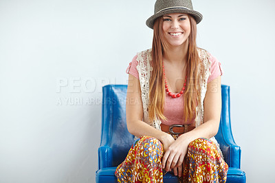 Buy stock photo Home, woman and happy for fashion on chair with retro or vintage clothes on white wall. Female person, portrait and serious with jewelry for style, hipster and designer hat for funky trends and smile