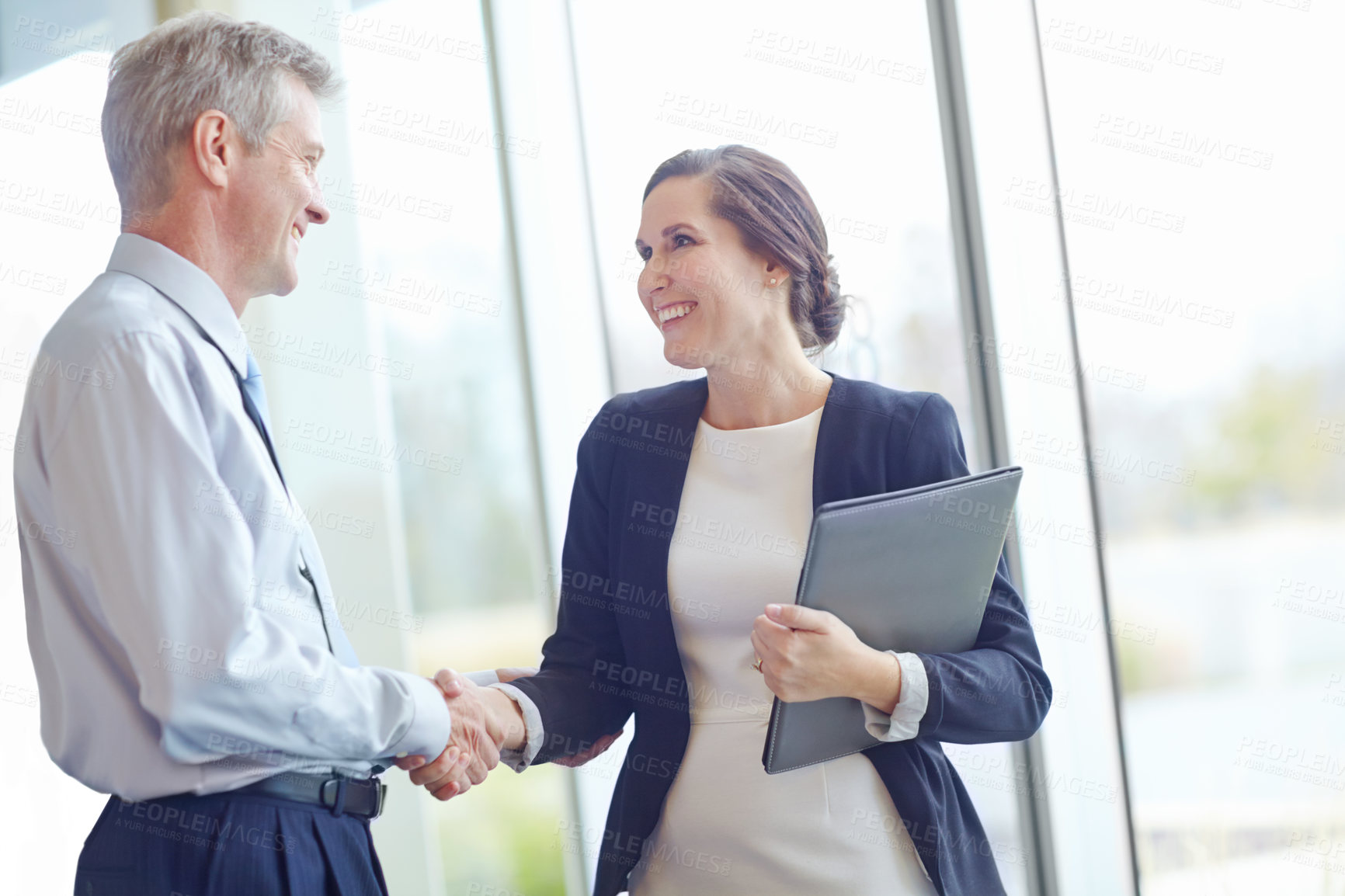 Buy stock photo Handshake, hiring and laptop with business people in office together for interview or recruitment. Computer, collaboration or smile with happy employee and mentor shaking hands in corporate workplace