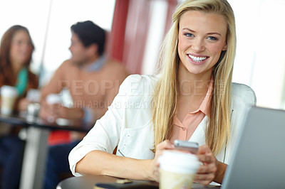 Buy stock photo A beautiful young woman using her smartphone in a busy coffeee shop