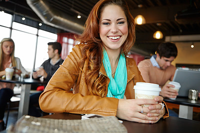Buy stock photo A beautiful young woman sitting in a coffee shop and enjoying some coffee