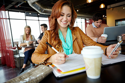 Buy stock photo A beautiful young university student using her smartphone in a coffeee shop while studying