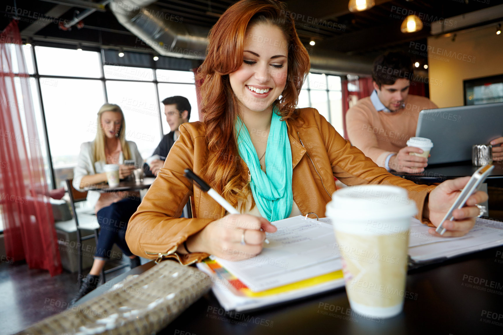 Buy stock photo Woman, writing and study with smartphone, paper and coffee for university, exam or working on project. Student, learning and happy for education, college and school assessment in campus cafeteria 