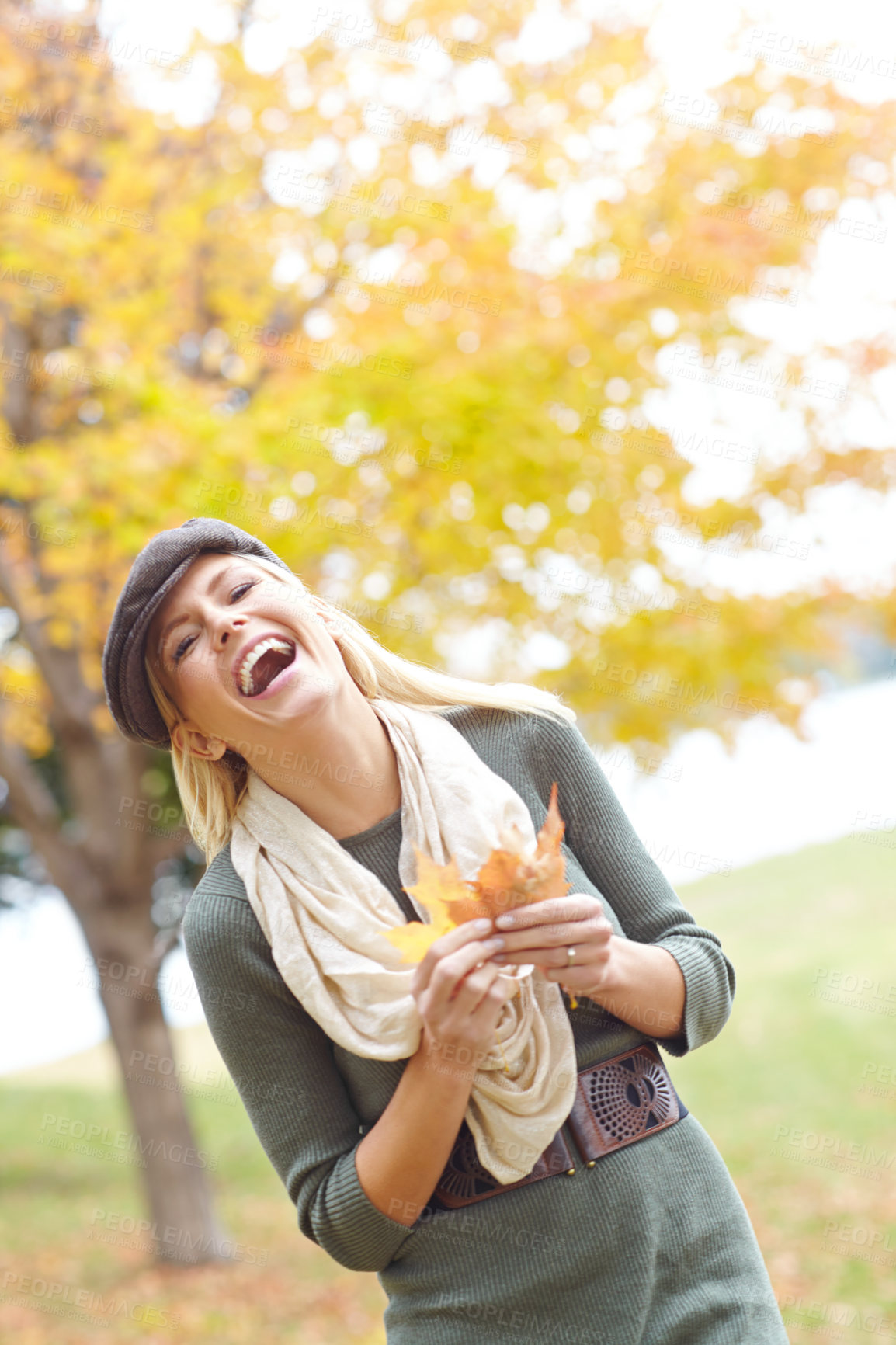 Buy stock photo Fashion, laughing and woman with leaf in nature for Autumn weather on holiday, getaway or vacation. Happy, outdoor and female person from Denmark with stylish outfit in park or field on weekend trip.