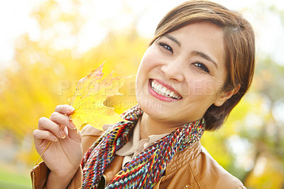 Buy stock photo Woman, autumn and portrait with leaf in park with smile, sustainability and adventure in nature. Korean person, face and travel with plant foliage in outdoor environment with relax, happy and holiday