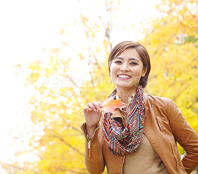 Buy stock photo Woman, autumn and portrait with leaf outdoor with smile, sustainability and adventure in nature. Korean person, face and travel with plant foliage in natural environment with relax, happy and holiday