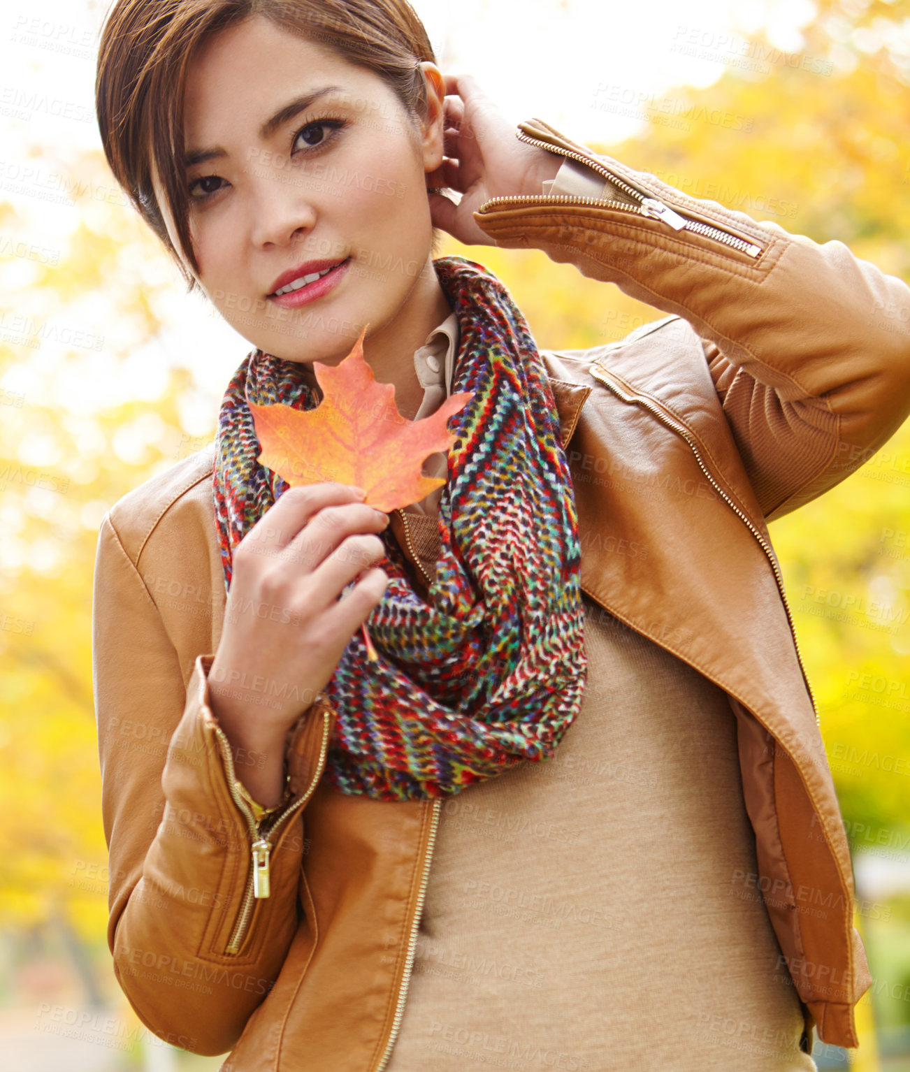 Buy stock photo Woman, autumn and portrait with leaf in nature with smile, sustainability and adventure in park. Korean person, face and travel with plant foliage in outdoor environment with relax, happy and holiday