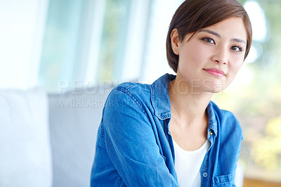 Buy stock photo An attractive Asian woman wearing a casual denim shirt relaxing at home