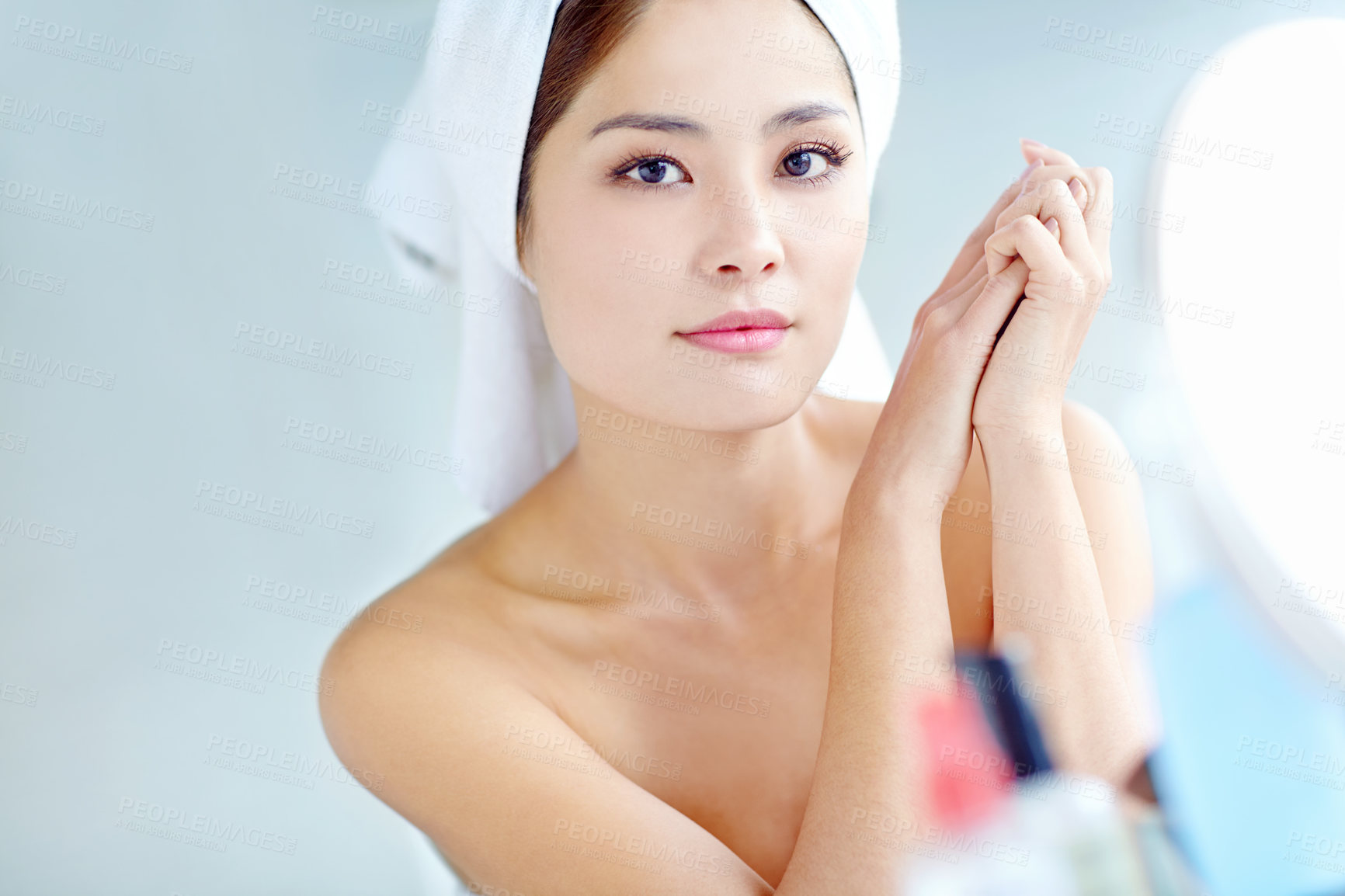 Buy stock photo Asian woman, bathroom and cosmetics by mirror, portrait and moisturizer bottle for change, wellness or smile in home. Person, towel and grooming routine with beauty, check and product for skincare