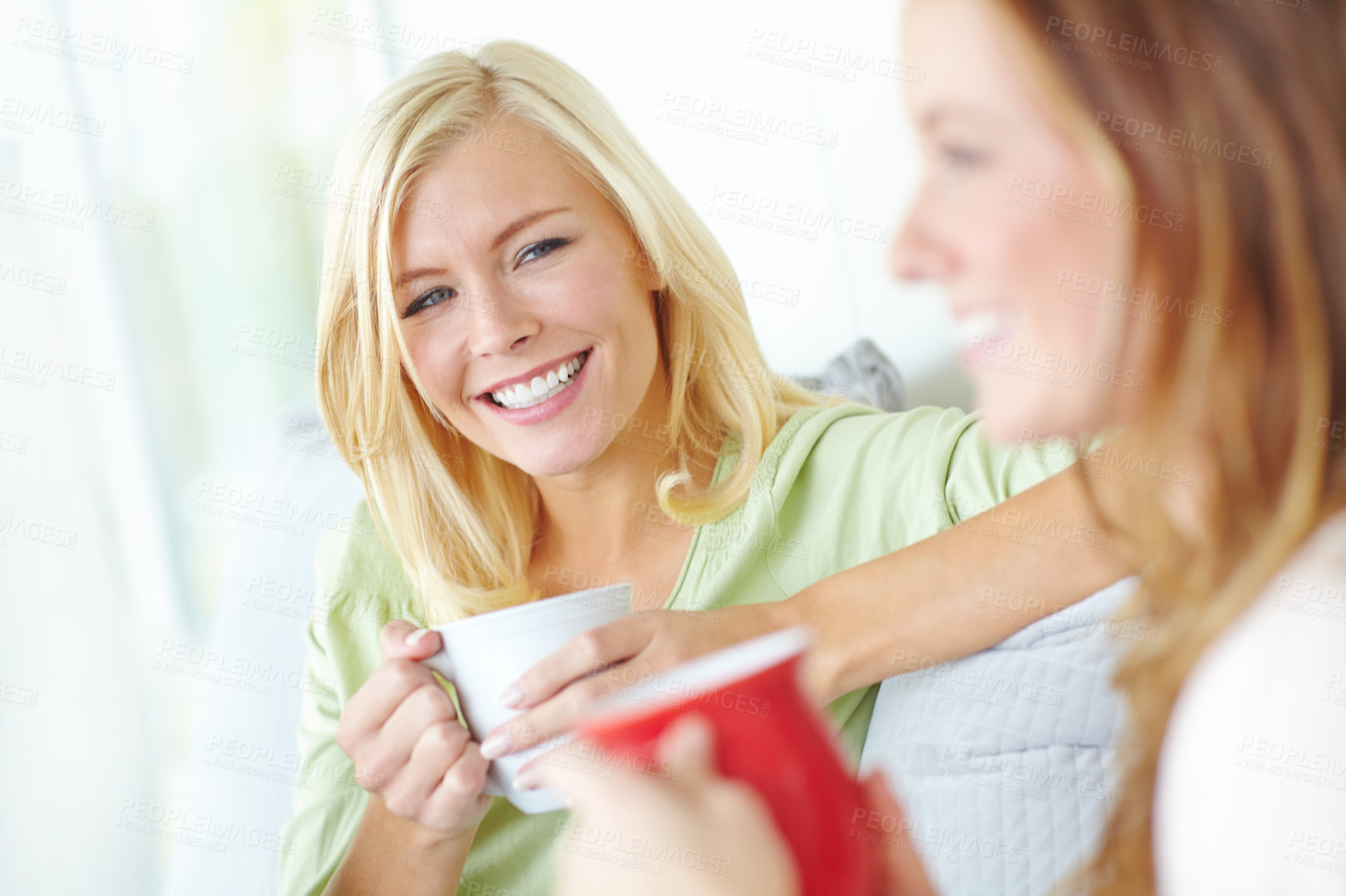 Buy stock photo Coffee, friends and women on sofa happy for bonding, conversation and relationship in home. Gossip, funny and people relax with drink, tea and mug in living room for talking, chat and social visit