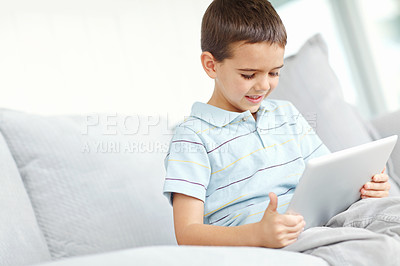 Buy stock photo Smile, tablet and kid in home for relax, reading ebook or streaming anime in living room. Boy, technology or child on sofa with learning app for education, watch show or cartoon addiction on internet