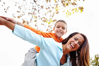 Buy stock photo Mother, boy and outdoor with flying on piggyback for fun on portrait with bonding, support and care. Low angle, parent and happy or smile with kid for child development, growth and childhood memories